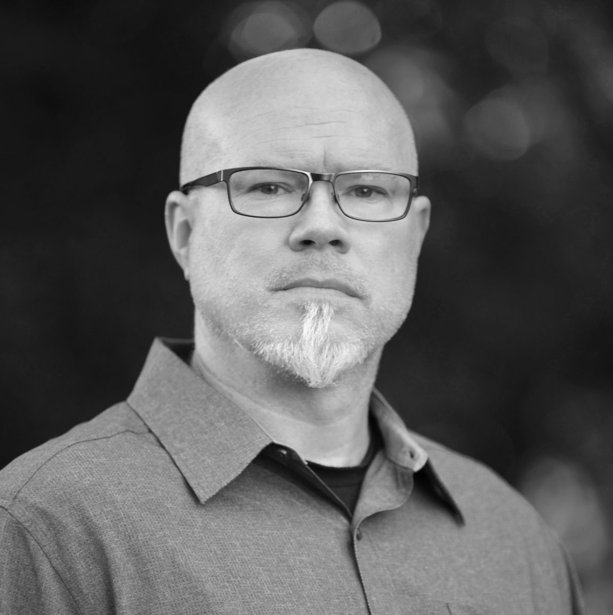 black and white headshot of assistant professor Chris Sancomb